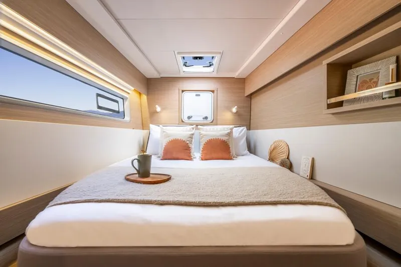  Yacht Photos Pics Luxurious cabin interior of 2025 Lagoon 43 yacht with cozy bed and modern decor.
