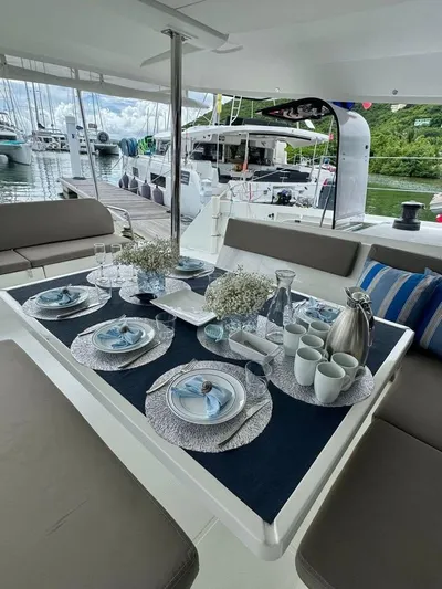  Yacht Photos Pics Elegant dining setup on 2015 Fountaine Pajot SABA 50 catamaran, docked with lush greenery backdrop.