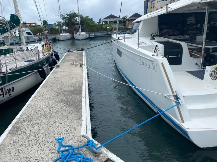  Yacht Photos Pics 2015 Fountaine Pajot SABA 50 catamaran docked at marina, side view.