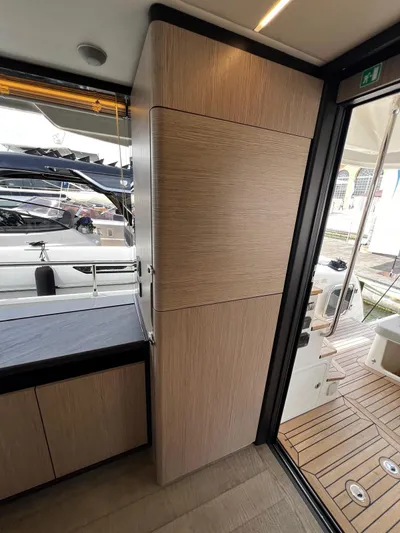  Yacht Photos Pics Interior view of 2025 Absolute NAVETTA 48 yacht, featuring sleek wood cabinetry and modern design.
