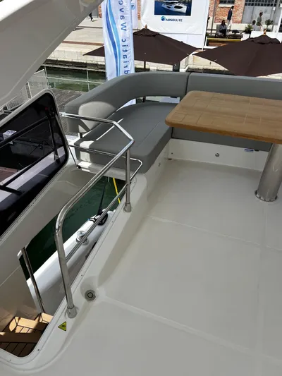  Yacht Photos Pics 2025 Absolute NAVETTA 48 yacht deck with seating and table, docked at marina.