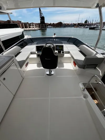  Yacht Photos Pics 2025 Absolute NAVETTA 48 yacht cockpit with modern seating and steering, docked in a marina.