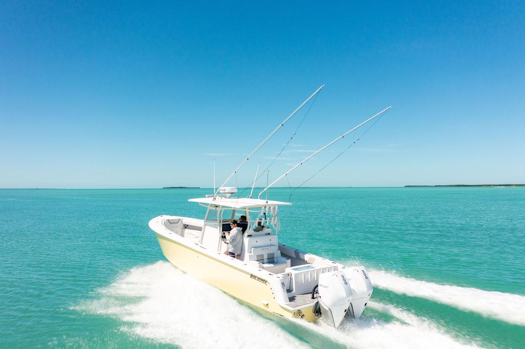 2023 Reef Runner 340 Center Console cruising on turquoise waters under clear blue sky.