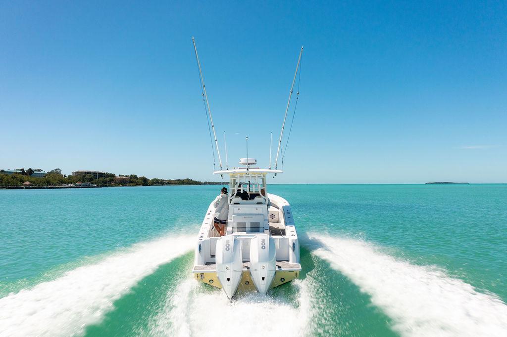 2023 Reef Runner 340 Center Console cruising on turquoise waters under clear blue sky.