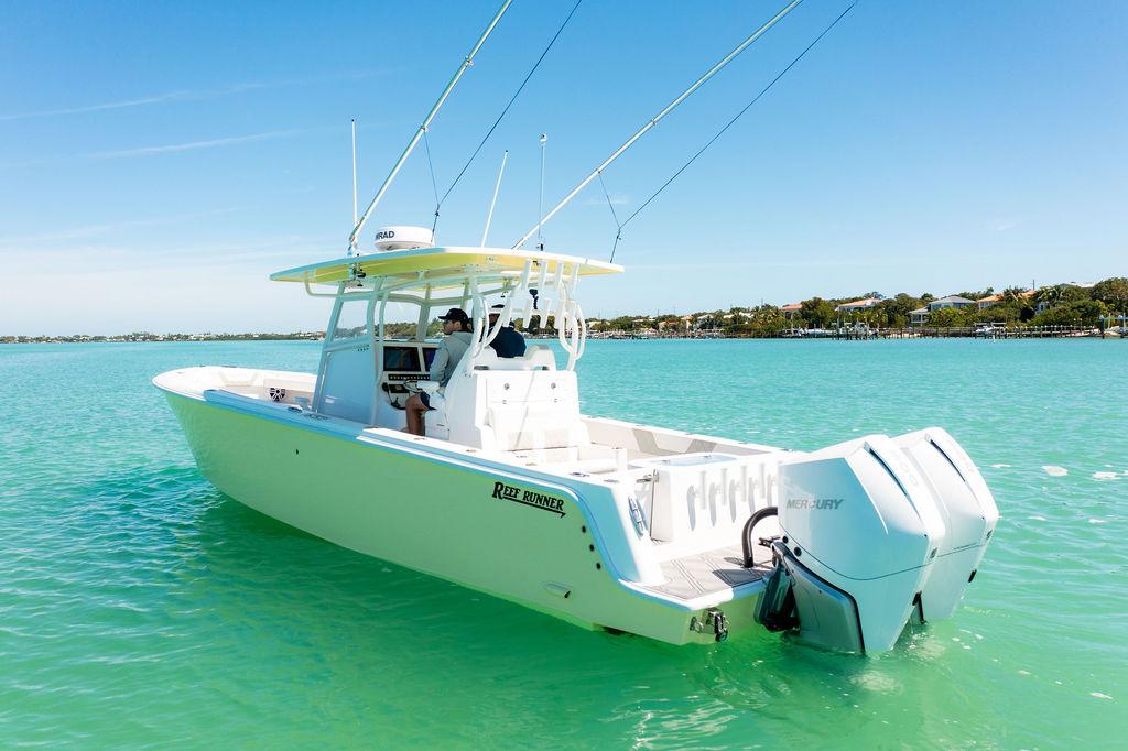 2023 Reef Runner 340 Center Console boat on turquoise water, featuring dual Mercury engines.