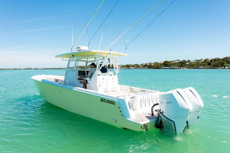 Showgirl Yacht Photos Pics 2023 Reef Runner 340 Center Console boat on turquoise water, featuring dual Mercury engines.