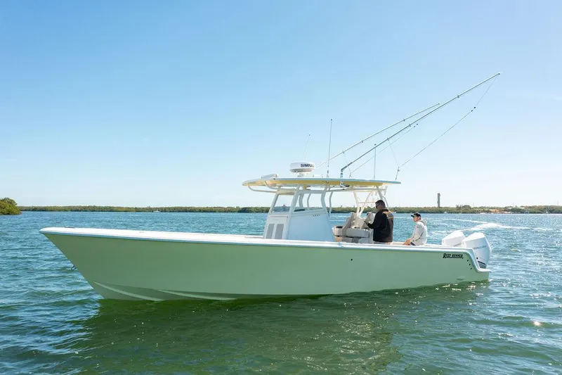 Showgirl Yacht Photos Pics 2023 Reef Runner 340 Center Console boat on calm water, clear sky background.