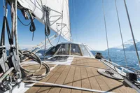 Sailing yacht deck with ropes, Custom 0ne Off model, 1991, ocean and mountains in background.