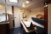 Cozy boat interior with seating, table, and nautical decor, Custom 0ne Off, 1991 model.