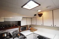 Compact boat kitchen with white cabinets, microwave, and skylight, Custom 0ne Off, 1991 model.