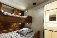 Bunk beds with patterned bedding in a cozy, custom 1991 interior space.