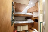 Compact wooden cabin interior with bunk beds, skylight, and fire extinguisher, Custom 0ne Off 1991.