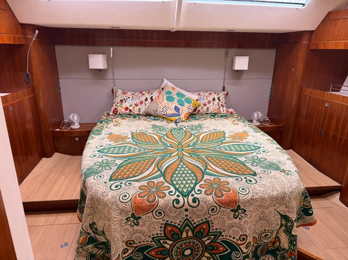 Marina Yacht Photos Pics Luxurious Amel 55 yacht bedroom with vibrant floral bedding, wood paneling, and modern lighting.