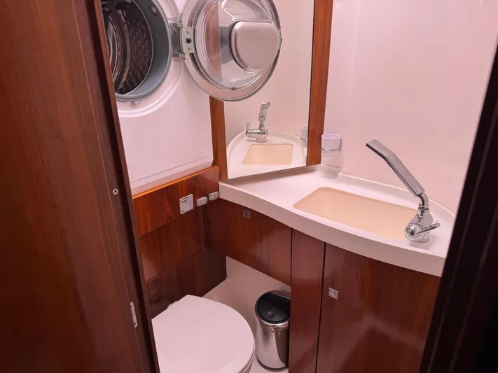 Marina Yacht Photos Pics Compact bathroom in 2012 Amel 55 yacht with wooden cabinetry and modern fixtures.