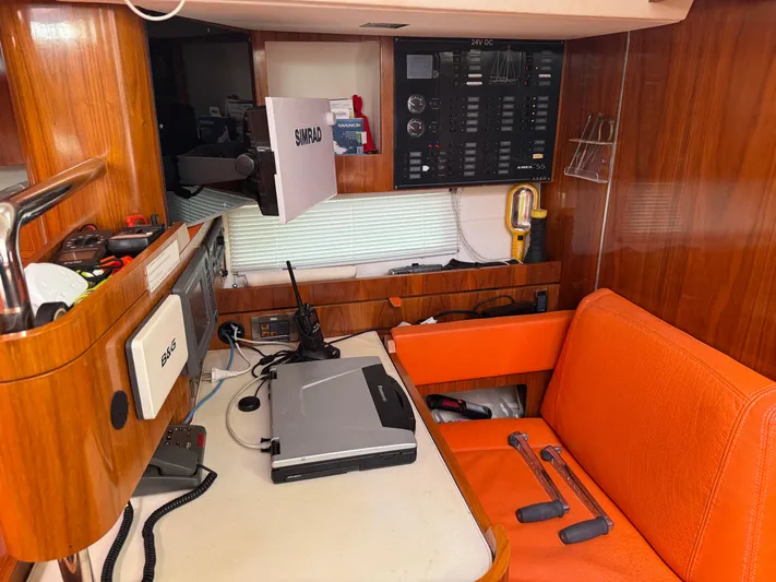 Marina Yacht Photos Pics Navigation station in 2012 Amel 55 yacht with orange seating and electronic equipment.