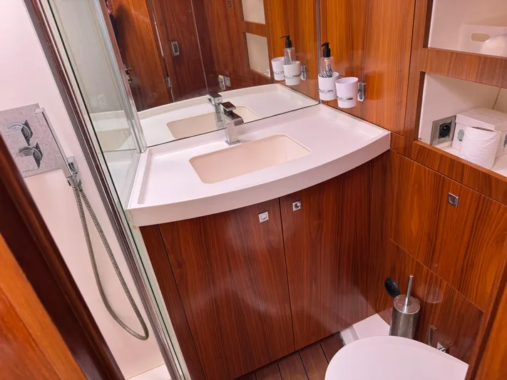 Marina Yacht Photos Pics Luxurious bathroom in 2012 Amel 55 yacht with wood finish and modern fixtures.