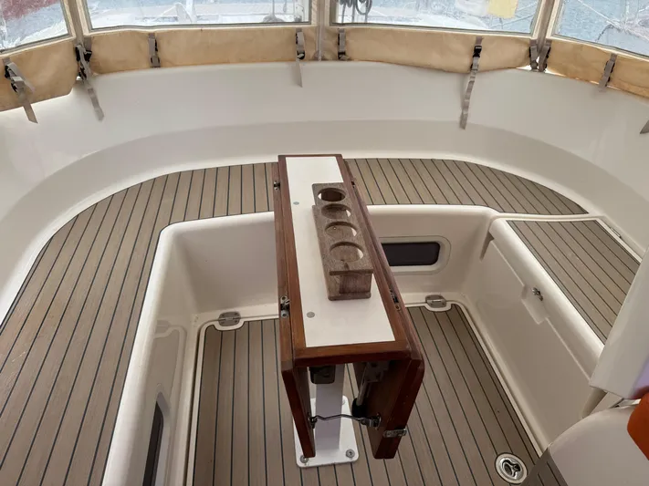 Marina Yacht Photos Pics Amel 55 yacht cockpit, 2012 model, featuring teak flooring and a central wooden table.