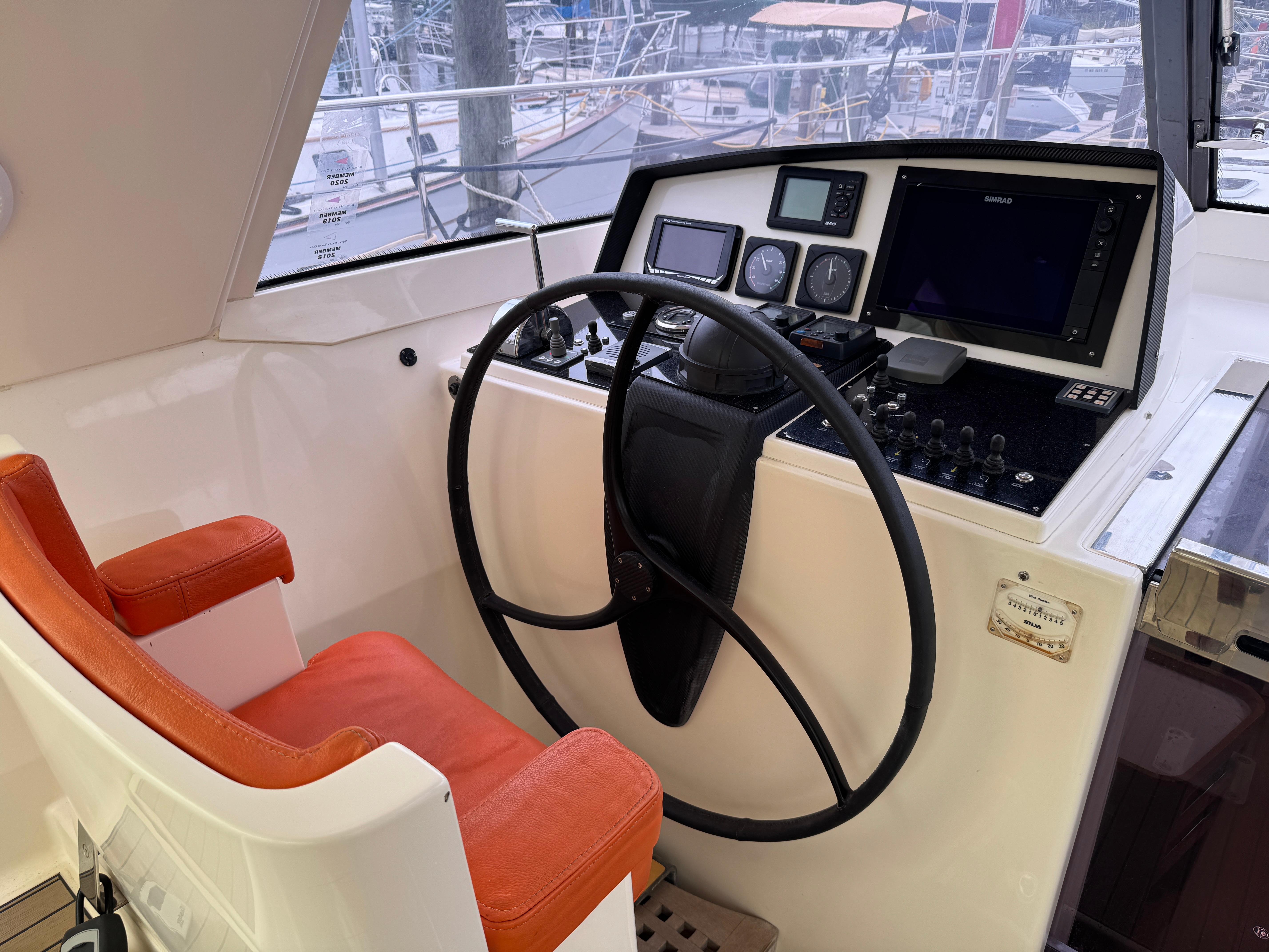 Helm of 2012 Amel 55 yacht with orange seat and navigation instruments.