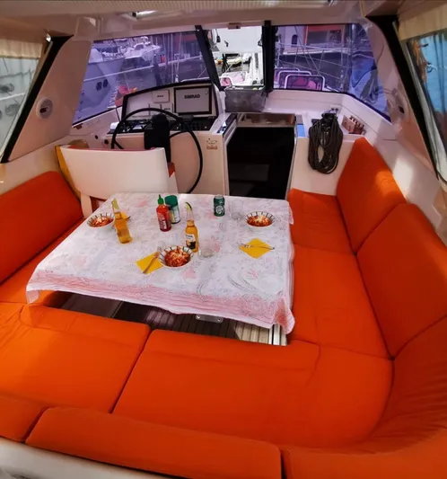 Marina Yacht Photos Pics Interior of 2012 Amel 55 yacht with orange seating and dining setup.