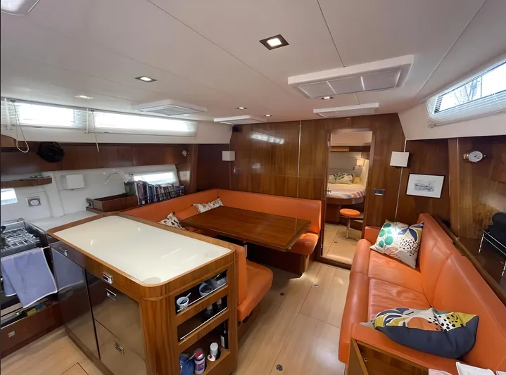 Marina Yacht Photos Pics Luxurious interior of a 2012 Amel 55 yacht with orange seating and wooden finishes.