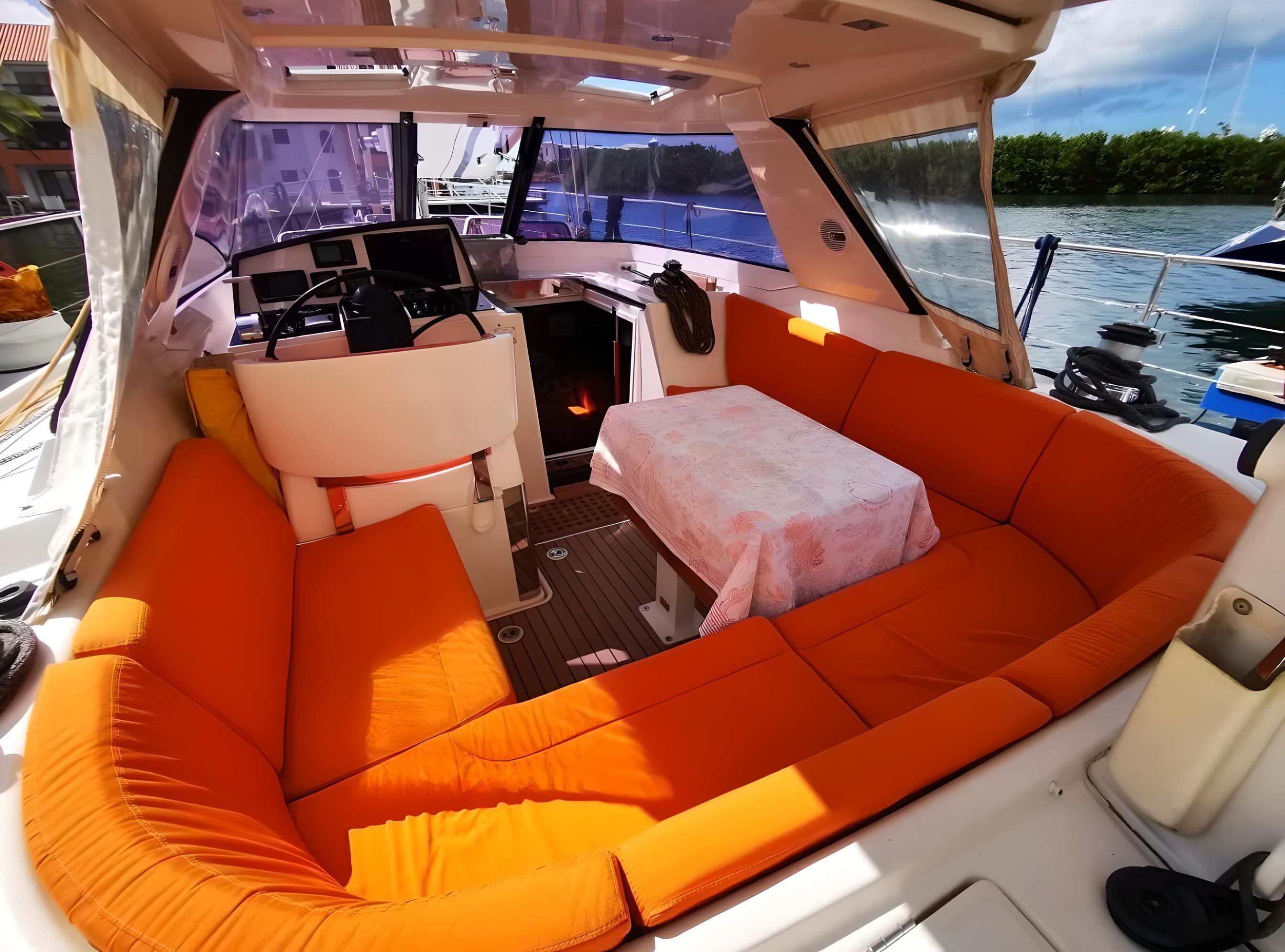Luxurious 2012 Amel 55 yacht interior with orange seating and dining area.