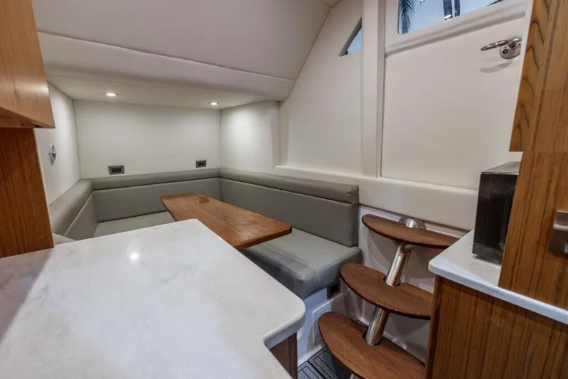  Yacht Photos Pics 2023 Front Runner 47 interior with modern seating, wooden table, and elegant staircase.