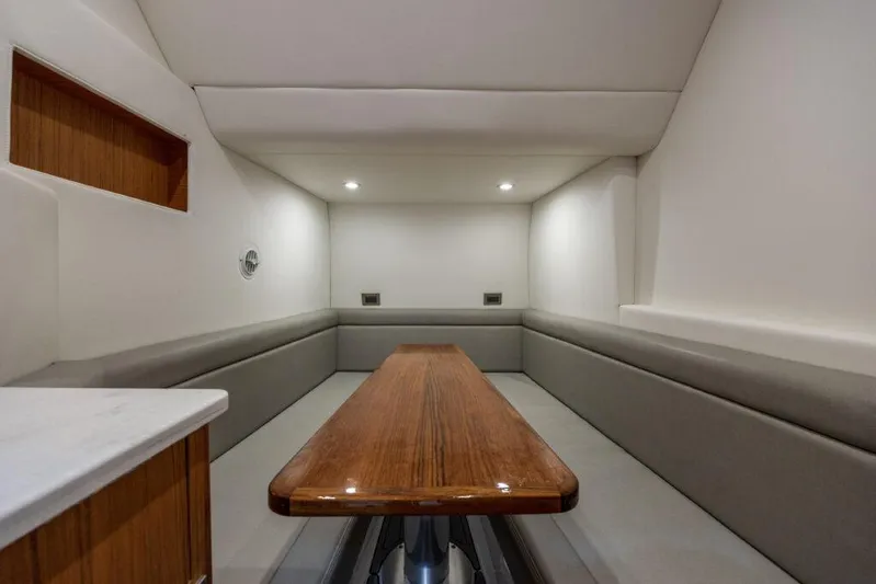  Yacht Photos Pics Luxurious interior of 2023 Front Runner 47 yacht with sleek wooden table and cushioned seating.