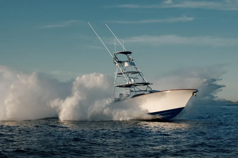 Yacht Photos Pics 2023 Front Runner 47 boat speeding on open water, creating dramatic waves.