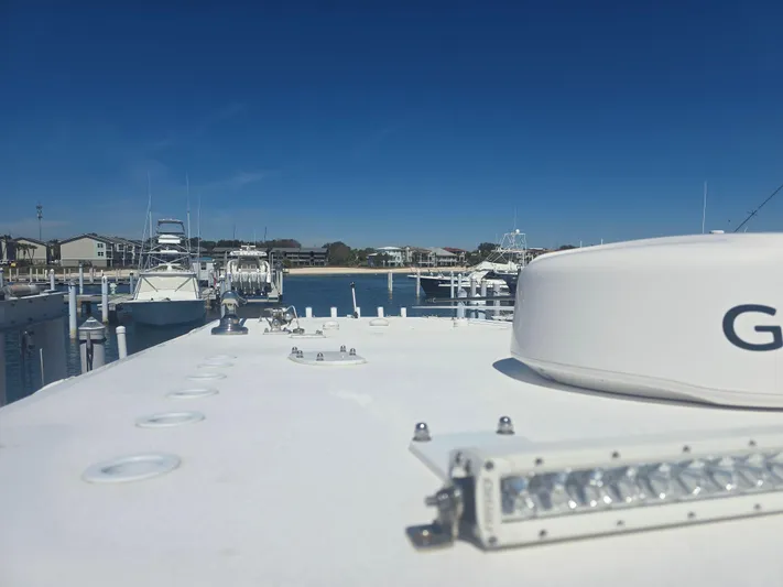  Yacht Photos Pics 2024 Invincible 43 Open Fisherman boat docked at a marina under clear blue skies.