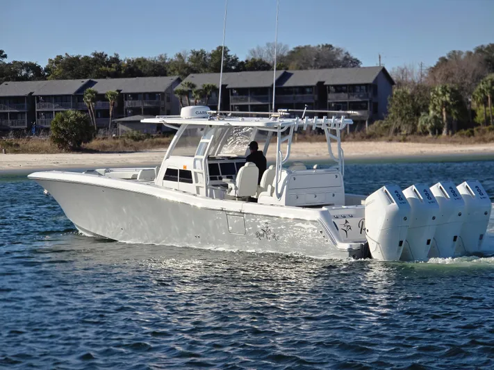  Yacht Photos Pics 2024 Invincible 43 Open Fisherman boat cruising on water near shoreline.