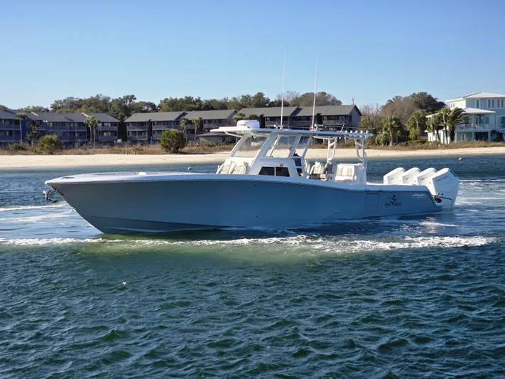  Yacht Photos Pics 2024 Invincible 43 Open Fisherman boat cruising on water near shoreline.
