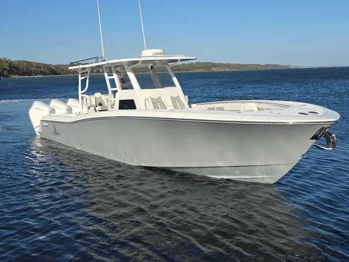  Yacht Photos Pics 2024 Invincible 43 Open Fisherman boat on calm water, showcasing sleek design and powerful engines.