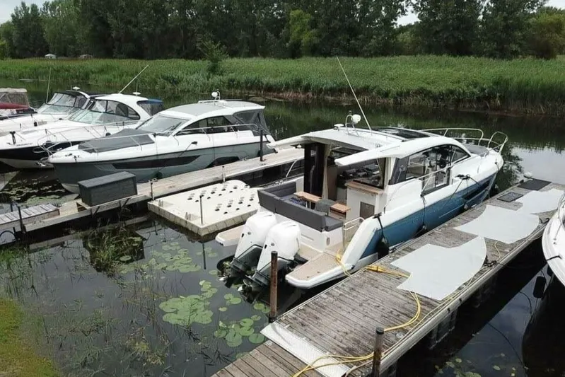  Yacht Photos Pics 2023 Sealine C335V yacht docked in a serene marina setting.