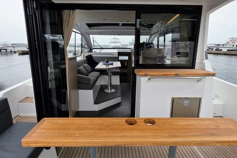  Yacht Photos Pics 2023 Sealine C335V yacht interior with modern seating and dining area, docked at marina.