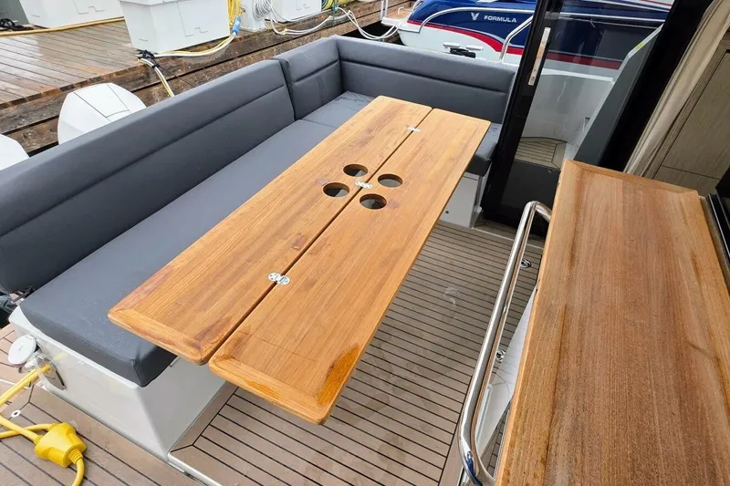  Yacht Photos Pics 2023 Sealine C335V yacht deck with wooden table and seating area.
