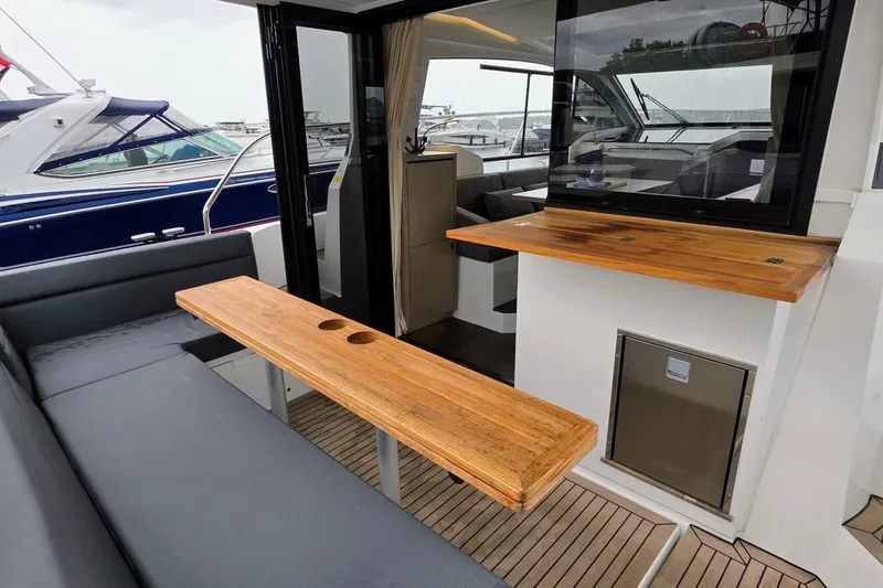  Yacht Photos Pics 2023 Sealine C335V yacht interior with wooden table and seating area.