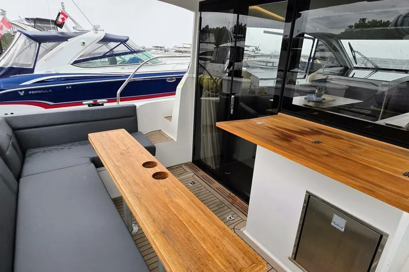  Yacht Photos Pics 2023 Sealine C335V yacht interior with wooden table, seating, and modern design.