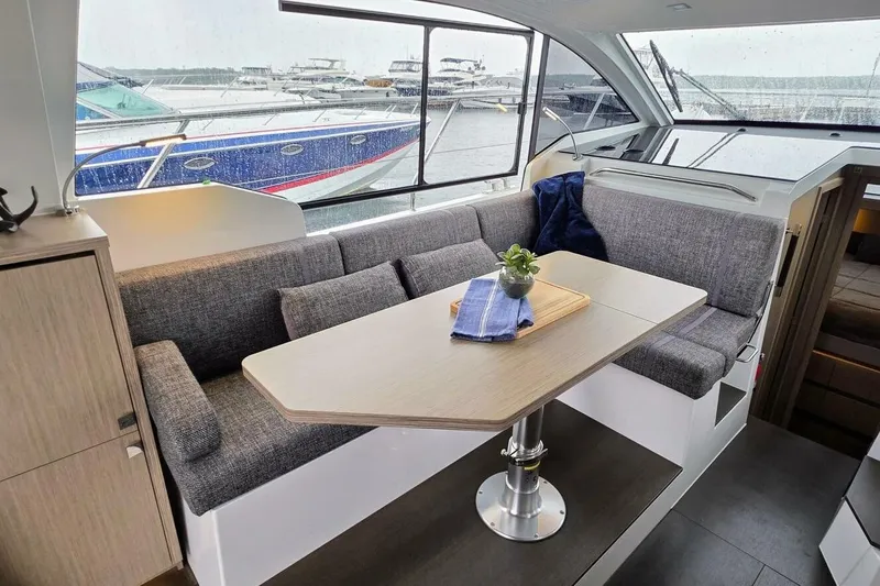 Yacht Photos Pics 2023 Sealine C335V yacht interior with cozy seating and dining table.