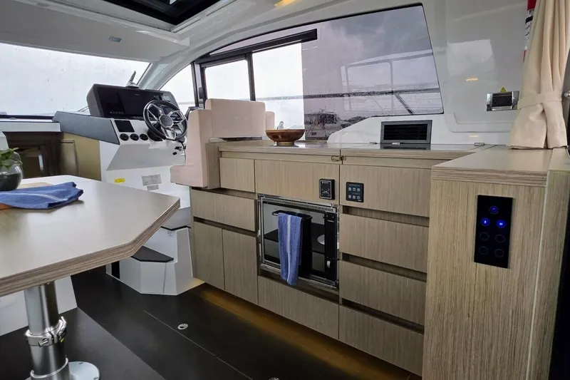  Yacht Photos Pics 2023 Sealine C335V yacht interior with modern helm, sleek cabinetry, and dining area.
