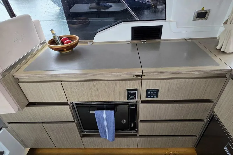  Yacht Photos Pics Modern kitchen interior of 2023 Sealine C335V yacht with sleek cabinetry and countertop.