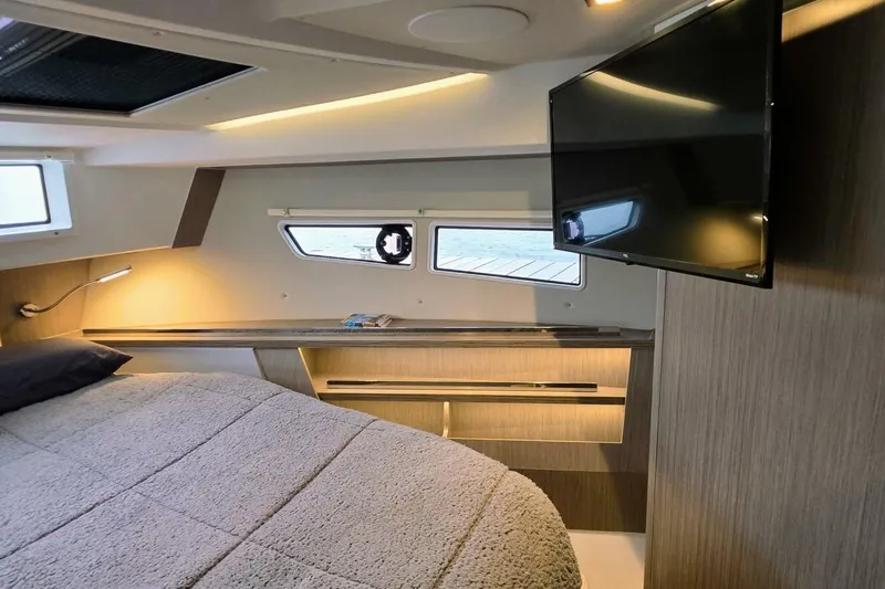 Yacht Photos Pics 2023 Sealine C335V yacht interior with cozy bed, modern lighting, and wall-mounted TV.