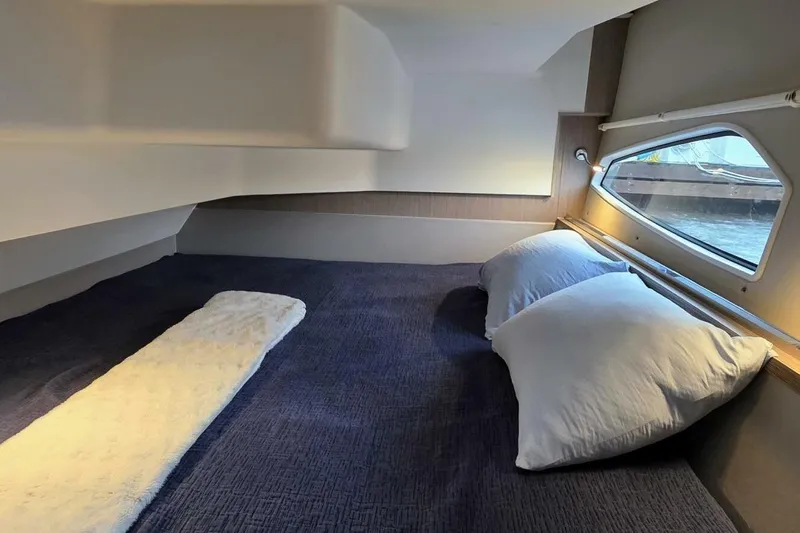  Yacht Photos Pics Cozy cabin interior of 2023 Sealine C335V yacht with comfortable bedding and window view.
