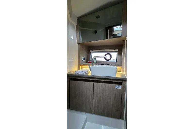  Yacht Photos Pics Modern bathroom interior of 2023 Sealine C335V yacht with sleek sink and wooden cabinetry.
