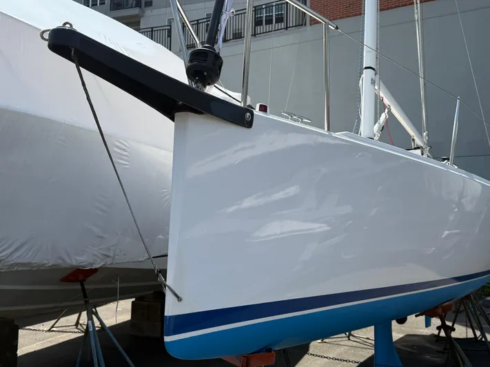 Evelyn Yacht Photos Pics 2022 J Boats J/9 sailboat bow with sleek white hull and blue stripe.