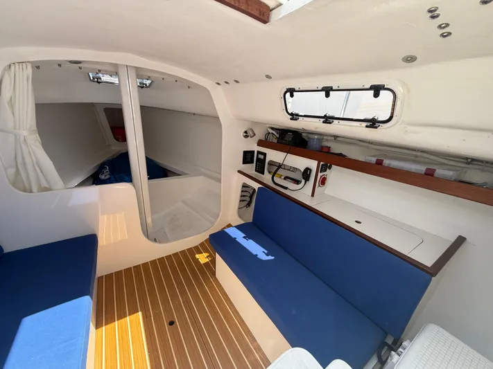 Evelyn Yacht Photos Pics Interior of 2022 J Boats J/9 sailboat with blue seating and wood flooring.