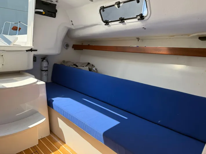Evelyn Yacht Photos Pics 2022 J Boats J/9 interior with blue seating and wooden accents.