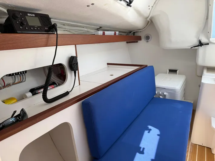 Evelyn Yacht Photos Pics 2022 J Boats J/9 interior with blue seating, radio, and storage compartments.