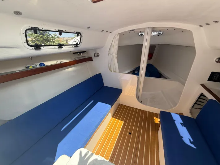 Evelyn Yacht Photos Pics Interior of 2022 J Boats J/9 sailboat with blue seating and wood flooring.