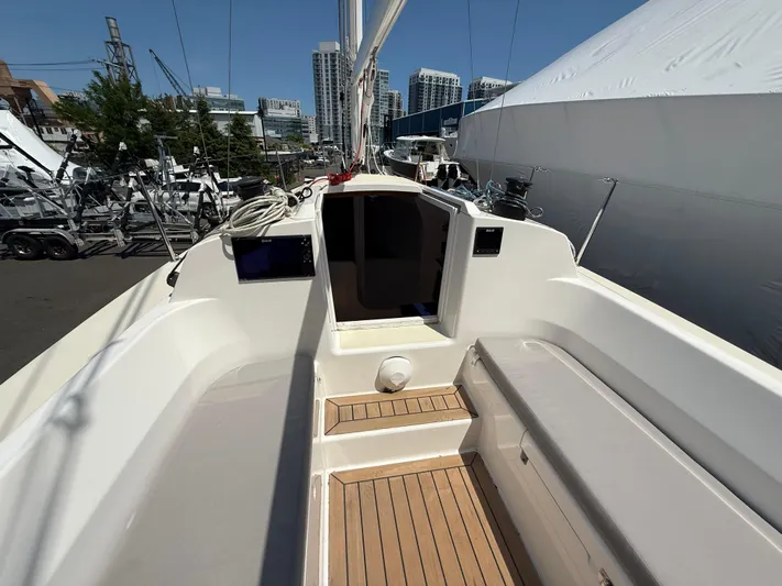 Evelyn Yacht Photos Pics 2022 J Boats J/9 sailboat cockpit with wooden flooring, docked in a marina.