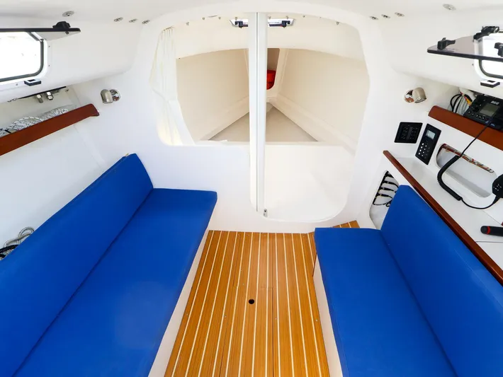 Evelyn Yacht Photos Pics Interior of 2022 J Boats J/9 sailboat with blue seating and wood flooring.